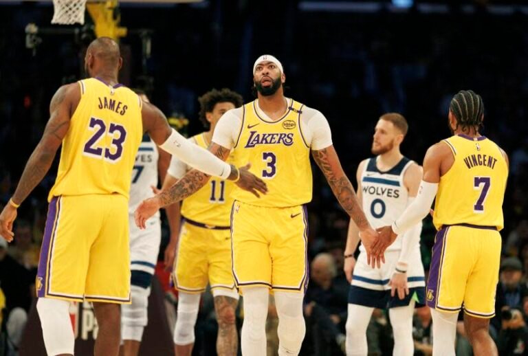 Lakers forward Anthony Davis reaches out to slap LeBron James and Gabe Vincent after scoring.