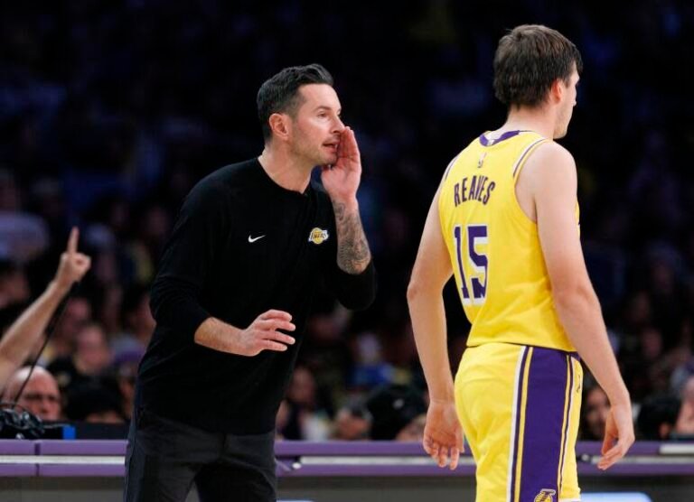 Lakers coach JJ Redick calls out instructions as guard Austin Reaves (15) walks by during a game