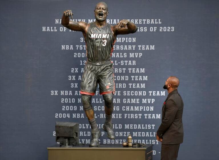 Former Miami Heat NBA basketball player Dwyane Wade looks at a bronze statue in his image during its unveiling ceremony.