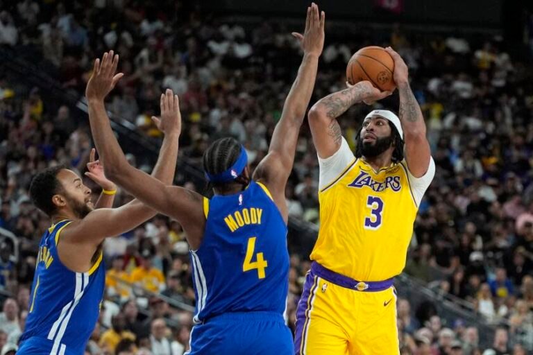 Los Angeles Lakers forward Anthony Davis (3) shoots over Golden State Warriors guard Moses Moody (4) during the first half of an NBA preseason basketball game Tuesday, Oct. 15, 2024, in Las Vegas. (AP Photo/John Locher)