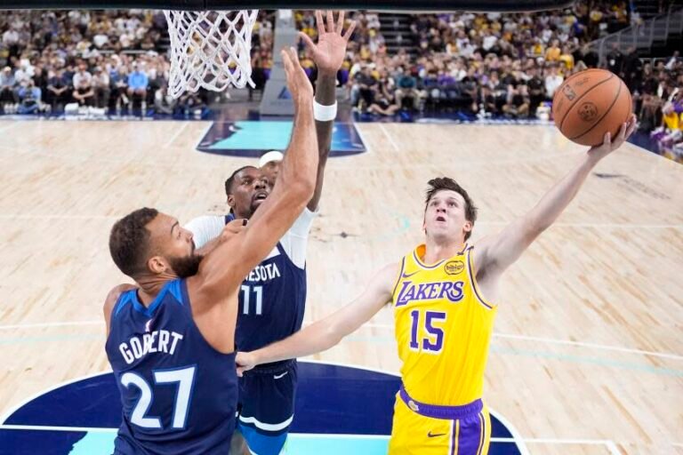 Los Angeles Lakers guard Austin Reaves, right, shoots as Minnesota Timberwolves center Rudy Gobert, left, and center Naz Reid defend during the first half of a preseason NBA basketball game, Friday, Oct. 4, 2024, in Palm Desert, Calif. (AP Photo) /Mark J. Terrill)