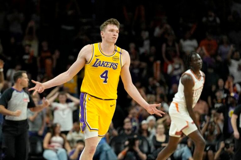 Los Angeles Lakers guard Dalton Knecht (4) celebrates his 3-pointer as Phoenix Suns center Bol Bol, right, looks on during the second half of an NBA preseason basketball game Thursday, Oct. 17, 2024, in Phoenix. The Lakers won 128-122 in overtime. (AP Photo/Ross D. Franklin)