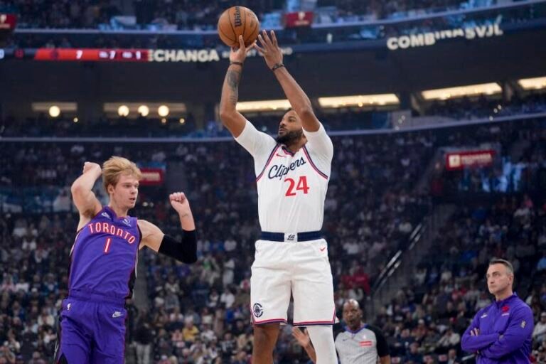 Los Angeles Clippers guard Norman Powell (24) shoots over Toronto Raptors guard Gradey Dick.