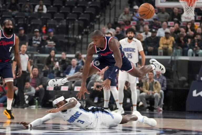 Los Angeles Clippers guard Kris Dunn (8) and Orlando Magic guard Kentavious Caldwell-Pope (3) battle for a loose ball during the first half of an NBA basketball game in Inglewood, Calif., Wednesday, Nov. 20, 2024. ( AP) Photo/Eric Thayer)