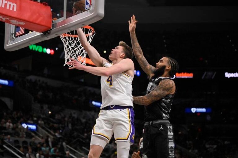 Los Angeles Lakers' Dalton Knecht (4) drives to the basket against San Antonio Spurs' Julian Champagnie during the first half of an Emirates NBA Cup basketball game, Friday, Nov. 15, 2024, in San Antonio. (AP Photo/Darren Abate)