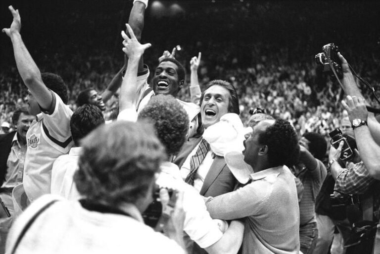 Los Angeles Lakers head coach Pat Riley is swarmed by fans and players as he and Lakers Mike Cooper leave the court.