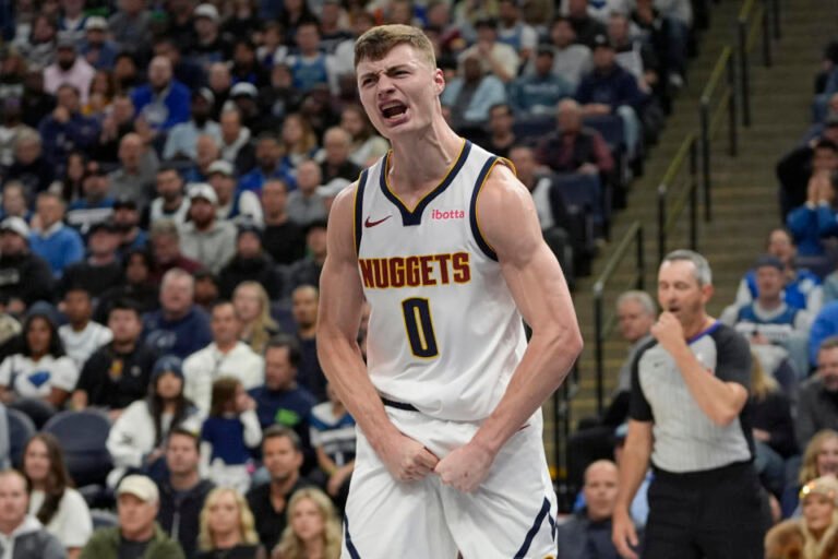 Denver Nuggets guard Christian Braun (0) celebrates after taking a shot during a foul during the first half of an NBA basketball game against the Minnesota Timberwolves, Friday, Nov. 1, 2024, in Minneapolis. (AP Photo/Abbie Parr)